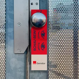 Jugendliche im roten Arbeitsoverall blicken zuversichtlich in die Kamera