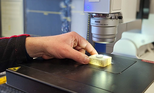 Gerodur Auszubildender Werkstoffprüfer arbeitet am Mikroskop