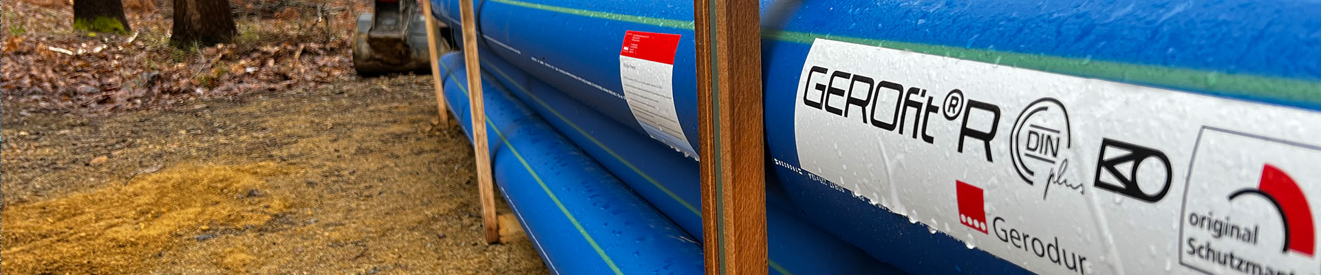 Palette mit Gerodur GEROfit R Schutzmantel-Triknwasserrohren auf einer Wiese