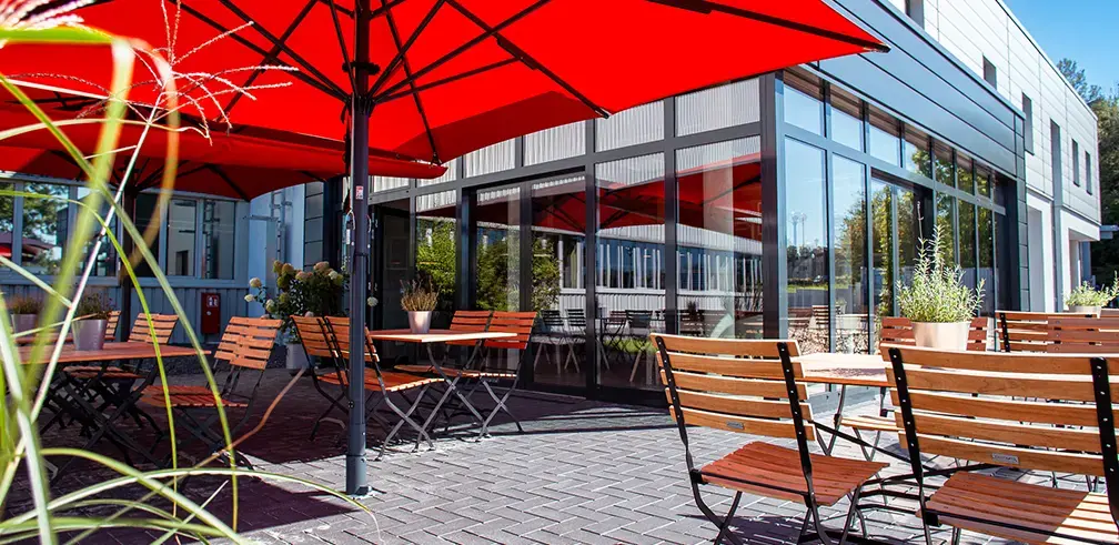 Aussenansicht der Gerodur Kantine im Sommer mit Sonnenschirmen